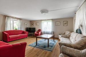 a living room with two couches and a table at Nice cottage at Bolmstad Sateri by Lake Bolmen in Bolmsö