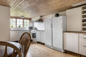 a kitchen with white appliances and a wooden ceiling at Nice cottage at Bolmstad Sateri by Lake Bolmen in Bolmsö