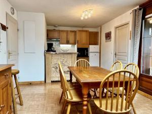 a kitchen and dining room with a wooden table and chairs at Appartement Flumet, 3 pièces, 6 personnes - FR-1-505-109 in Flumet