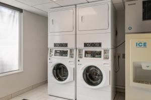 a laundry room with three washer and dryer machines at Holiday Inn Express Hotel & Suites - The Villages, an IHG Hotel in The Villages