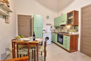 a kitchen with a table and a green refrigerator at Casa Francesca in Avola