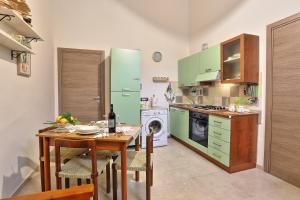 uma cozinha com uma mesa e um frigorífico verde em Casa Francesca em Avola