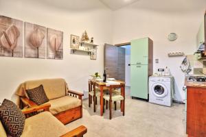 uma sala de estar com uma cozinha com uma mesa e uma máquina de lavar roupa em Casa Francesca em Avola