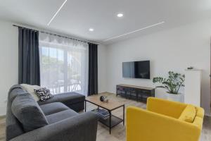 a living room with a couch and yellow chairs at NV Sun 23 by Aneo Travel in Novi Vinodolski