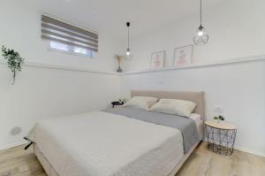 a white bedroom with a bed and a window at NV Sun 23 by Aneo Travel in Novi Vinodolski