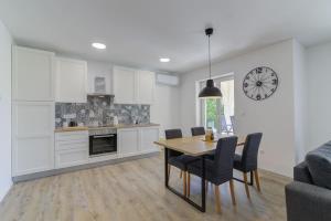a kitchen and dining room with a table and chairs at NV Sun 23 by Aneo Travel in Novi Vinodolski