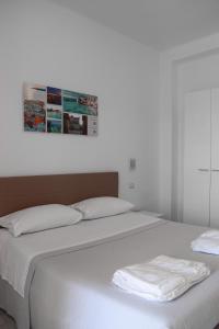 ガリポリにあるLa Scoglieraのベッド2台(白いシーツ付)、壁の絵画
