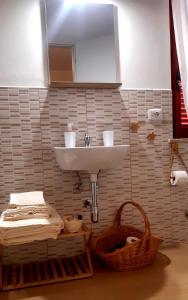 a bathroom with a sink and a basket at A Casa Di Nonna B&B in Tortoreto Lido