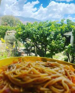 a yellow plate of spaghetti sitting on a table at El Convento de Tilcara in Tilcara