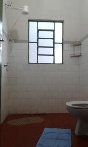 a bathroom with a toilet and a window at Casa para temporada in Serra Negra