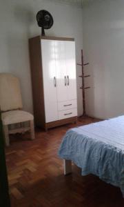 a bedroom with a bed and a chair and a dresser at Casa para temporada in Serra Negra