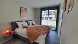 een slaapkamer met een bed en een groot raam bij Pool & Snooker Villa in Finestrat +28 foto's