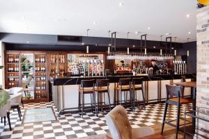 a bar in a restaurant with bar stools at Y Seler in Aberaeron