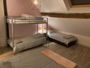 PraslayにあるGîtes du Noyerの二段ベッド2台とラグが備わる客室です。