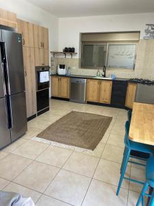a kitchen with a stainless steel refrigerator and a table at שלוות הגולן in Ani'am