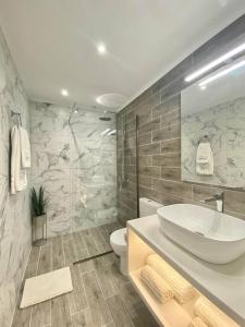 bagno bianco con lavandino e servizi igienici di Elia Room & Garden II (new entry) a Kontokali