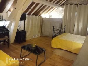 ein Schlafzimmer mit einem Bett und einem Tisch in einem Zimmer in der Unterkunft La Sablonnière de Rochefort in Rochefort-en-Yvelines