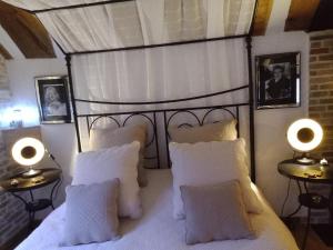ein Schlafzimmer mit einem Bett mit weißen Kissen und zwei Lampen in der Unterkunft La Sablonnière de Rochefort in Rochefort-en-Yvelines