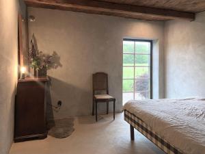 ein Schlafzimmer mit einem Bett, einem Stuhl und einem Fenster in der Unterkunft Rönnebröd in Rönnebröd