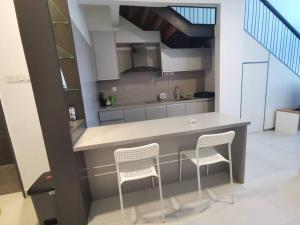 a kitchen with a counter and two chairs in it at Superview Duplex with WiFi & Netflix in Cyberjaya