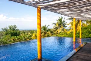 a swimming pool in a resort with a view of the ocean at Over The Hill in Pūvār