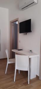 Elle comprend un bureau blanc avec une télévision et une chaise blanche. dans l'établissement Molto Benissimo, à Otrante