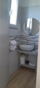 een badkamer met een wastafel en een spiegel bij Molto Benissimo in Otranto
