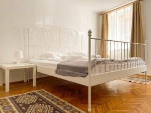 1 dormitorio con cama blanca y ventana en White Moon Apartment, en Brasov