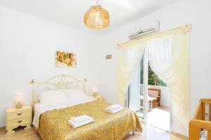 a white bedroom with a bed and a window at Rosa 's house in Palekastron