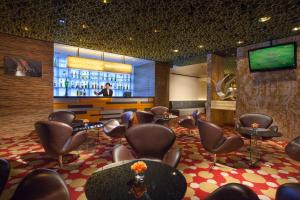 a waiting room with chairs and a bar with a tv at Park Hotel Hong Kong in Hong Kong