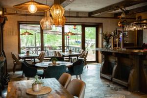 a restaurant with tables and chairs and a bar at Mėlynojo karpio namas in Kintai