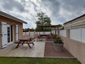 une terrasse avec une table de pique-nique et un banc dans l'établissement LES LANDES DU MEDOC, à Hourtin