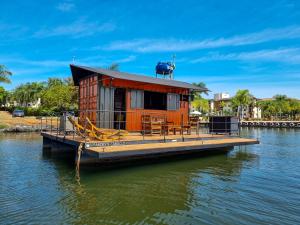 una casa naranja en un muelle en el agua en House Boat "Faroeste Caboclo" en Brasilia