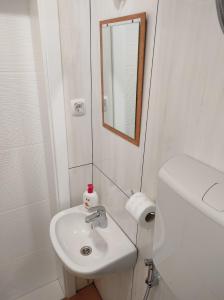 a white bathroom with a sink and a mirror at Villa The Cave in Blagaj