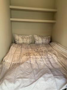 un letto bianco con due cuscini in una camera da letto di Notodden Sentrum Apartment NO 7 a Notodden