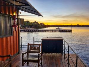 un barco con dos sillas sentado en un muelle en House Boat "Faroeste Caboclo", en Brasilia