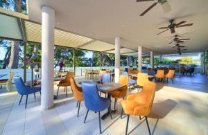 a restaurant with blue chairs and tables and windows at Hotel Bor in Krk