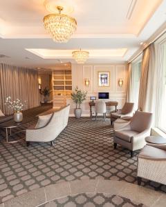 a hotel lobby with chairs and a chandelier at Fru Haugans Hotel in Mosjøen