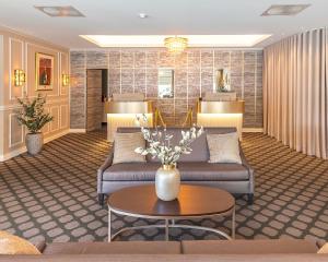 a lobby of a hotel with couches and a table at Fru Haugans Hotel in Mosjøen