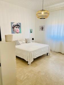 VISTA MARE في كروتوني: غرفة نوم بيضاء مع سرير و لوحة على الحائط