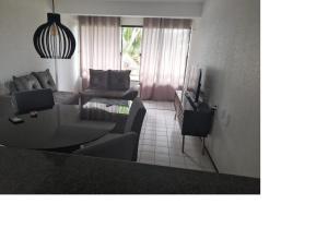 uma sala de estar com um sofá e uma mesa em Aps na praia do Futuro lazer e piscina 2 quartos, Van Cartier em Fortaleza