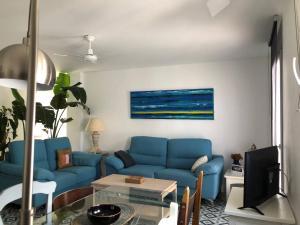 a living room with a blue couch and a table at ABA DALÍ in Conil de la Frontera