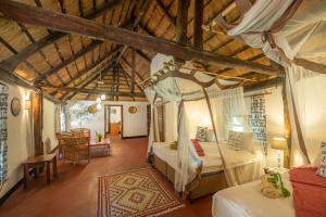 a bedroom with a canopy bed in a room with wooden ceilings at Pioneer Camp in Lusaka