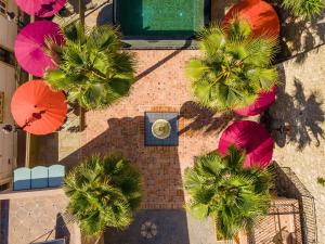 阿爾布費拉的住宿－Vila Origens Boutique Hotel Albufeira – Adults Only，享有棕榈树和遮阳伞的建筑的顶部景色