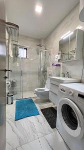 a white bathroom with a washing machine in it at Melodia del Mare in Kotor