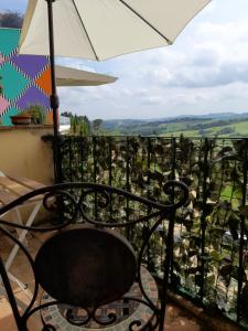 a chair sitting on a balcony with an umbrella at Rustico “I Bastioni” in Peccioli