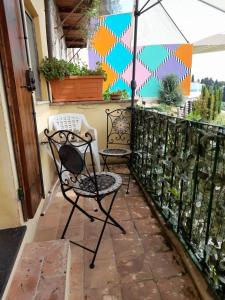 a patio with two chairs and an umbrella at Rustico “I Bastioni” in Peccioli