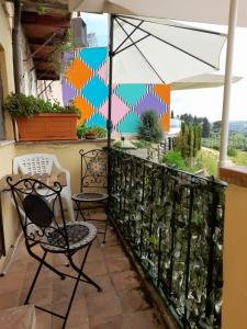 a patio with two chairs and an umbrella at Rustico “I Bastioni” in Peccioli