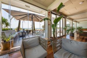 a living room with chairs and a balcony with plants at Hotel Maritim in Roses
