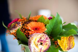 un vaso pieno di fiori colorati e foglie verdi di Belcasa Beach Suites & Lofts a Middelkerke